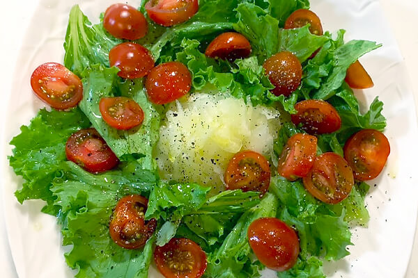 盛り付けた野菜に調味料をかける